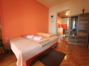 Apartment Tamarut في كريكفينيسا: غرفة نوم بسرير بحائط برتقالي