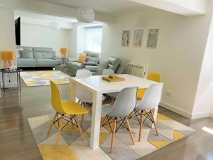 a living room with a white table and yellow chairs at Your luxurious and secluded retreat in Cornwall in Helston
