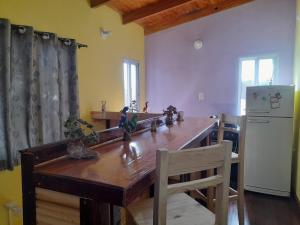 a kitchen with a wooden table and a refrigerator at APART FARFALLa in Puerto Iguazú