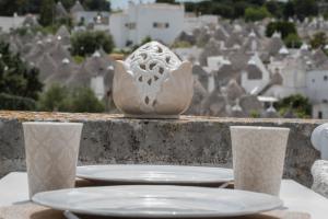 un tavolo con piatti e tazze in cima a una città di Trullo dei tramonti ad Alberobello