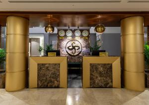 een lobby met gouden zuilen en een muur met een versiering bij Smayah Residence in Riyad