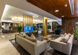 un vestíbulo con dos sofás y una TV. en Smayah Residence, en Riad