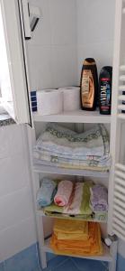um armário de casa de banho com toalhas e toalhas nas prateleiras em Casetta Mandarino em Ischia