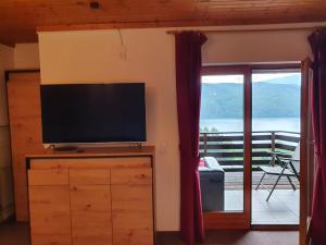 a living room with a flat screen tv on a dresser at Apartment Haus Starfach in Döbriach