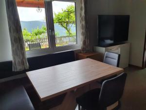 a living room with a wooden table and a large window at Apartment Haus Starfach in Döbriach