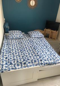 1 dormitorio con 1 cama con edredón azul y blanco en "Le Suez" Appartement au bord de mer Catalans-Pharo, en Marsella