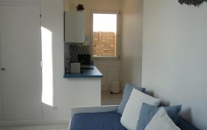 sala de estar con sofá azul y ventana en "Le Suez" Appartement au bord de mer Catalans-Pharo, en Marsella