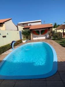 a large blue swimming pool in front of a house at Casa de temporada, Lagoa do Pau Coruripe-AL in Coruripe