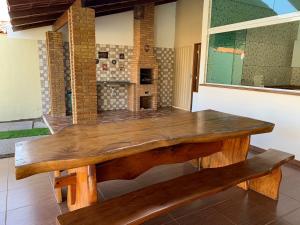 a wooden table and bench in a room at Casa de temporada, Lagoa do Pau Coruripe-AL in Coruripe