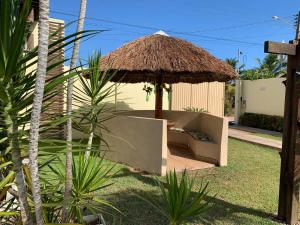 科魯里皮的住宿－Casa de temporada, Lagoa do Pau Coruripe-AL，院子里的椅子和雨伞
