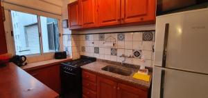 una cocina con fregadero y refrigerador en Depto de 2 ambientes zona Guemes, en Mar del Plata