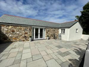 a stone patio in front of a building at Sunnyside Cow Shed one bedroom central Cornwall in Truro
