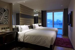 una camera d'albergo con due letti e una grande finestra di Crafa Harbour Hotel a Hong Kong