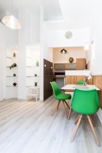 cocina y comedor con sillas verdes y mesa en Leda's Apartment Next to the Danube and Fashion Street en Budapest