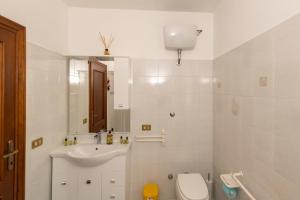 a white bathroom with a sink and a toilet at Casa Vacanze La Magnolia in Viterbo +34 photos