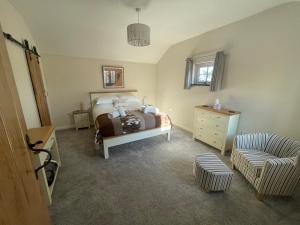 ein Schlafzimmer mit einem Bett und einem Stuhl in der Unterkunft Sunnyside Cow Shed one bedroom central Cornwall in Truro