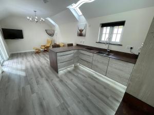 a large kitchen with a sink and a living room at Sunnyside Cow Shed one bedroom central Cornwall in Truro