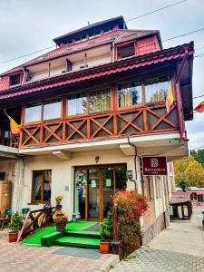 un bâtiment avec une pelouse verte devant lui dans l'établissement Hotel Belvedere, à Vatra Dornei