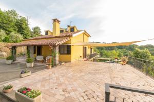 a yellow house with a patio in front of it at Casa Vacanze La Magnolia in Viterbo