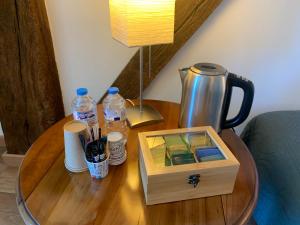 einen Holztisch mit einem Wasserkocher und einer Holzkiste darauf in der Unterkunft Maison Mard'Or Chambre Sylvaé in Mardor