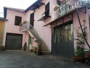 Casa rosa con escaleras y balcón en B&B Nonna BI, en Serravalle Scrivia