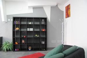 una estantería de libros negros en una sala de estar con sofá en How Beach,modern apartment close to the beach,WiFi, en Cassibile