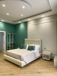 een slaapkamer met een groot wit bed en groene muren bij M&M Guest House in Ercolano