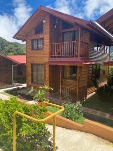 a large wooden house with a staircase in front of it at Clusia Lodge in El Copey