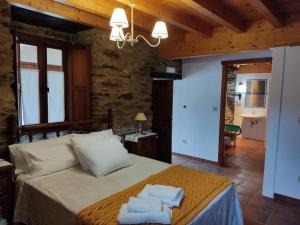 sypialnia z łóżkiem i dwoma ręcznikami na nim w obiekcie Casa Rural Penaquente w mieście Santa Marta de Ortigueira +37 zdjęć