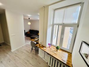 uma sala de estar com uma mesa e uma grande janela em Cozy apartments em Riga