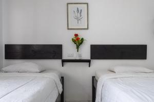 una habitación con 2 camas y un jarrón de flores en la pared en Hotel Cañas, en Cañas