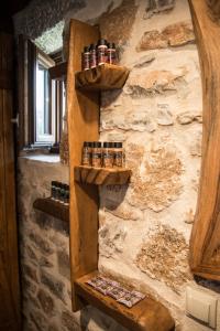 a wall with wooden shelves on a stone wall at Karyoupolis Lounge Cave House in Gythio