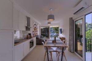 a kitchen with white cabinets and a table with chairs at CITRINE in Korčula