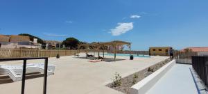 un patio con piscina e un padiglione con posti a sedere di bel Appartement vue sur le lac marin avec WIFI et piscine a Le Barcarès