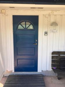 eine blaue Tür mit einem Fenster auf einem Haus in der Unterkunft Gustavsro i Apelviken Annex 1 in Varberg