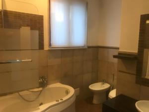 ein Badezimmer mit einer Badewanne, einem WC und einem Waschbecken in der Unterkunft Casalhouse Apartment in Brindisi
