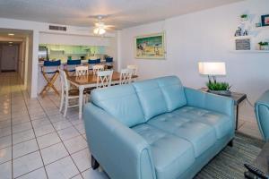 Una sala de estar con un sofá azul y una mesa. en Sand Dollar 1-306, en St. Augustine