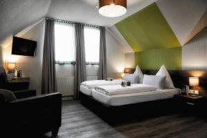 een hotelkamer met een groot bed en een bank bij Konsumhotel am Park - Nebenhaus Berghotel Oberhof - nur Übernachtung in Oberhof