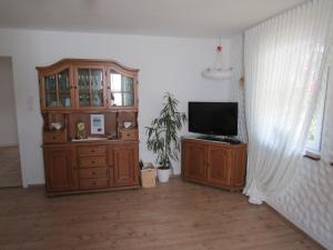 ein Wohnzimmer mit einem TV und einem Holzschrank in der Unterkunft Ferienwohnung Liesel in Hornberg