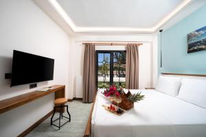 a hotel room with a bed and a flat screen tv at MELİTYA Hotels in Kalekoy