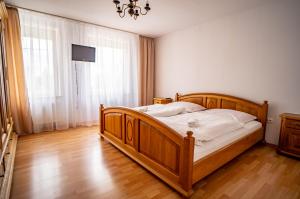 a bedroom with a wooden bed and a chandelier at Hotelik Maria in Szczytno