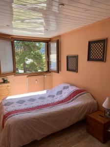 a bedroom with a bed and two windows at Gréolières les neiges in Gréolières