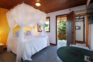 a bedroom with a bed with a canopy at Pousada Arraial Colonial in Arraial d'Ajuda