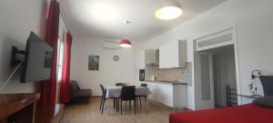a room with a table and chairs and a kitchen at Casa vacanze Lucilla in Cecina