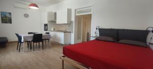 a bedroom with a red bed and a table with chairs at Casa vacanze Lucilla in Cecina