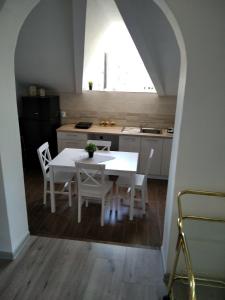 een keuken met een witte tafel en stoelen in een kamer bij Tina in Tekija