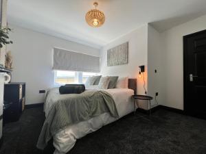 une chambre avec un grand lit et une fenêtre dans l'établissement Modern mid terrace villa, Royston, Barnsley, à Royston