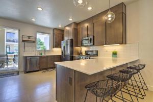 a kitchen with a large island with bar stools at Sunny Resort Townhome and Balcony and Pool Access in St. George