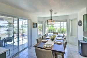 a dining room with a table and chairs and windows at Luxe Home with Detached Casita and Furnished Patio! in Bullhead City