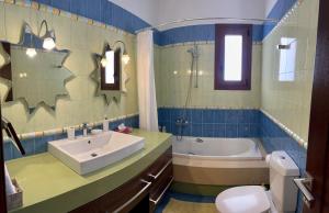 a bathroom with a sink and a tub and a toilet at Lindos Anatoli Luxury Villa in Líndos +25 photos